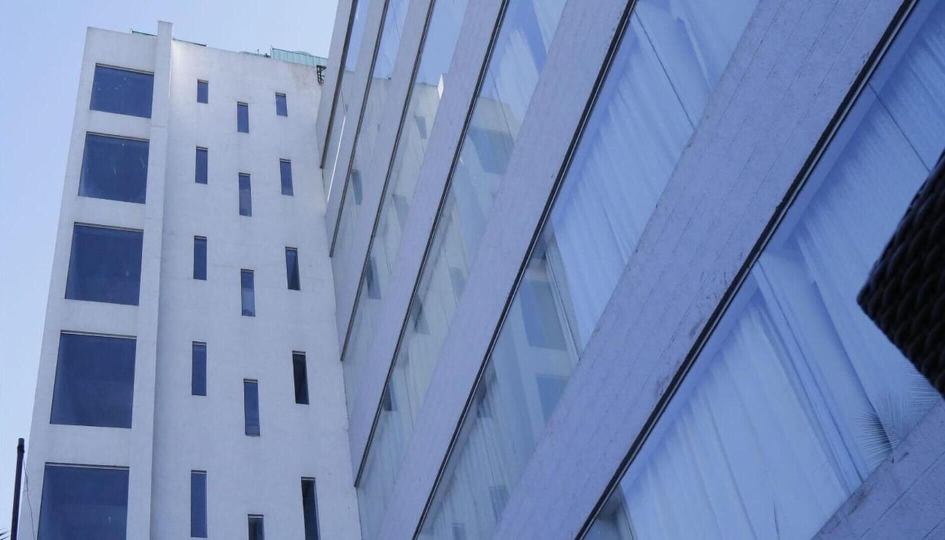Um edifício moderno com várias janelas e fachada de vidro.