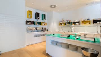 Une cuisine moderne avec des meubles blancs, des plans de travail verts et divers appareils de cuisine.