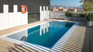 Ein Pool auf dem Dach mit freiem Blick auf die Stadtlandschaft, einem Rettungsring und einer Leiter.