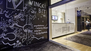 Ein modernes Interieur mit einer schwarzen Wand, die weiße künstlerische Gestaltungselemente und Schriftzüge zeigt.