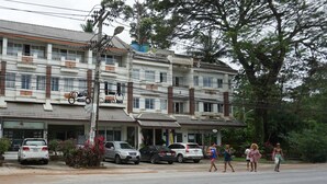 Un edificio de varios pisos con varios coches estacionados delante.