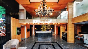 A spacious lobby with a chandelier, a reception desk, and a seating area. - Quality Inn Gurgaon (Gurugram)