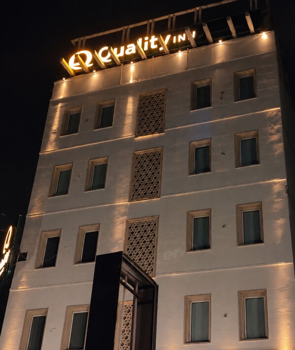 A multi-story building with a sign that reads 'Quality Inn' at the top. - Quality Inn Gurgaon (Gurugram)