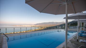 Vista despejada de una piscina con un paisaje urbano y montañas al fondo.
