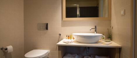 A modern bathroom with a toilet, sink, and mirror.