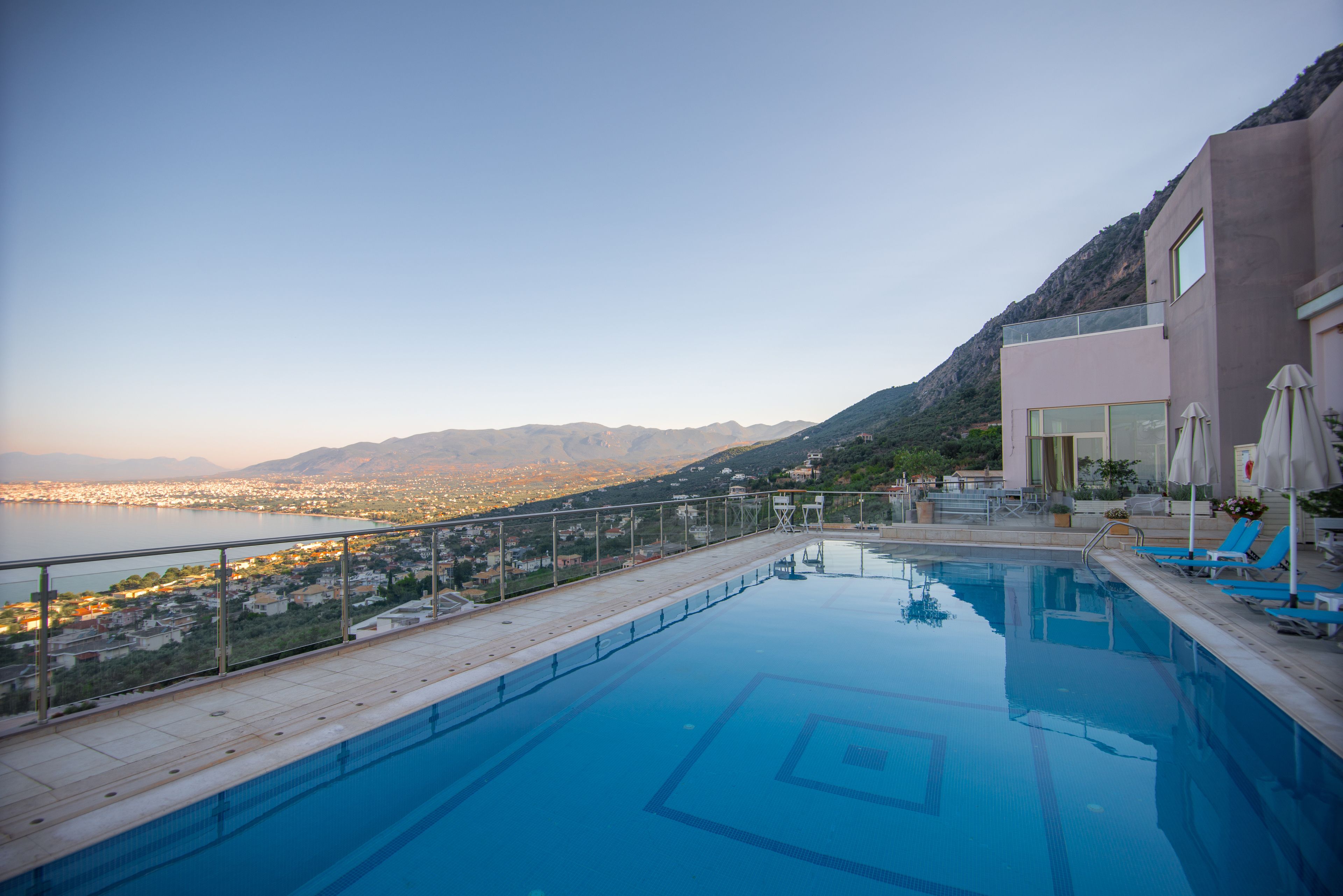 A swimming pool with a view of a city and mountains.