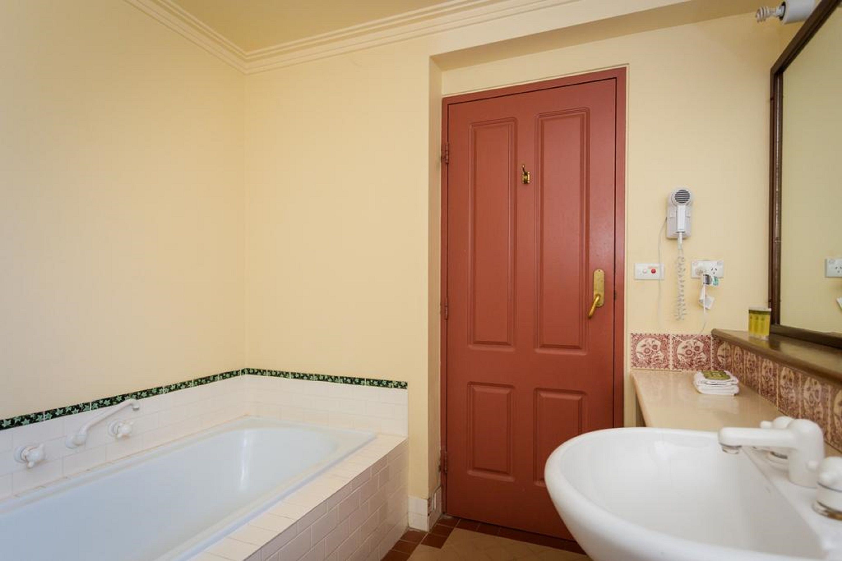 Une salle de bain avec une baignoire, un lavabo et une porte.