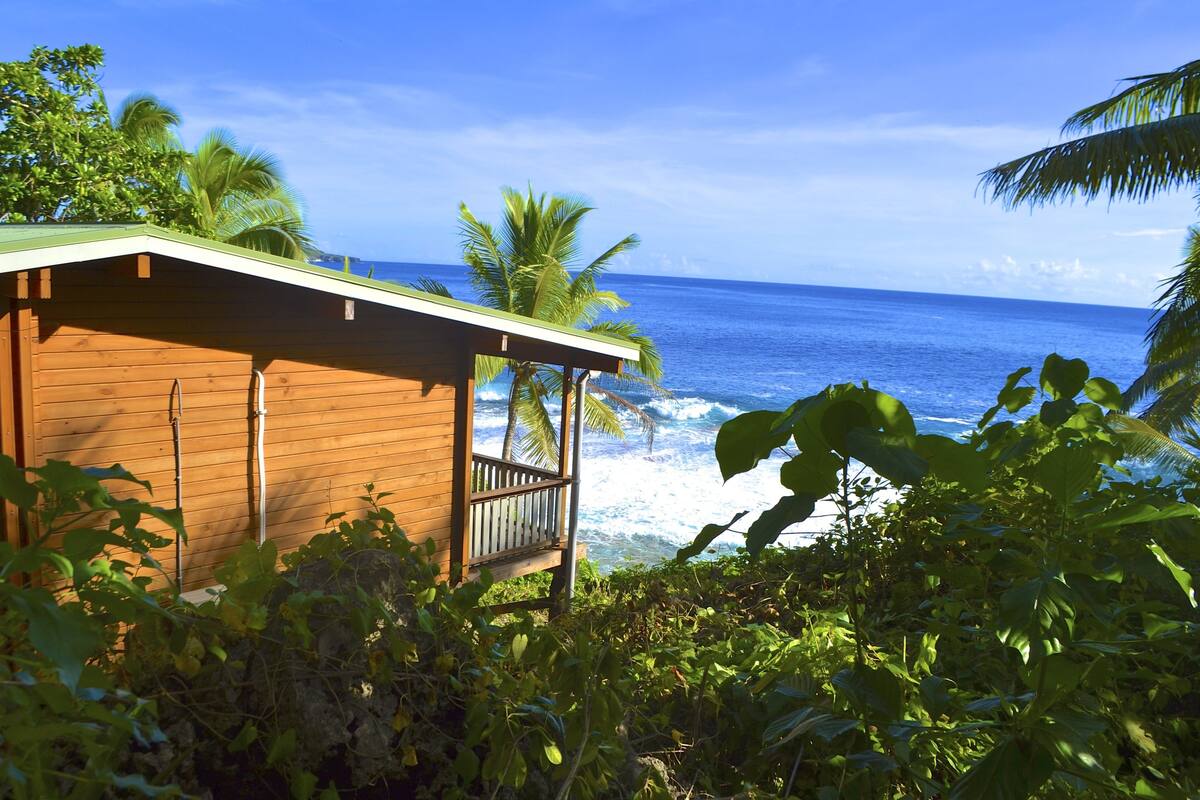 A wooden building with a balcony overlooking the ocean.