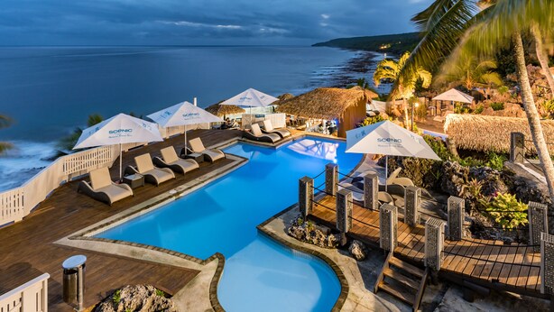 A pool area with lounge chairs and umbrellas, overlooking the ocean. - Scenic Matavai Resort Niue (Tamakautoga)
