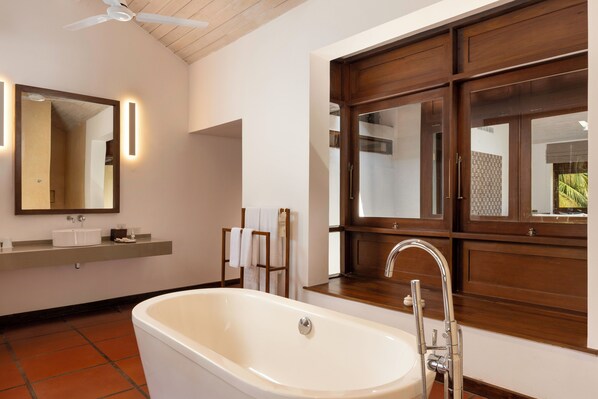 A modern bathroom with a freestanding bathtub, a large mirror, and a wooden vanity. - Jetwing Lagoon Wellness, A Luxury Reserve - Adults Only (Negombo)