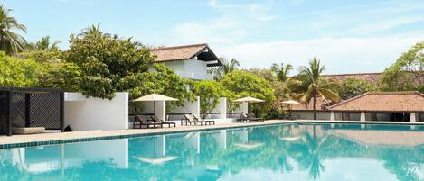 Una piscina al aire libre, sombrillas, tumbonas