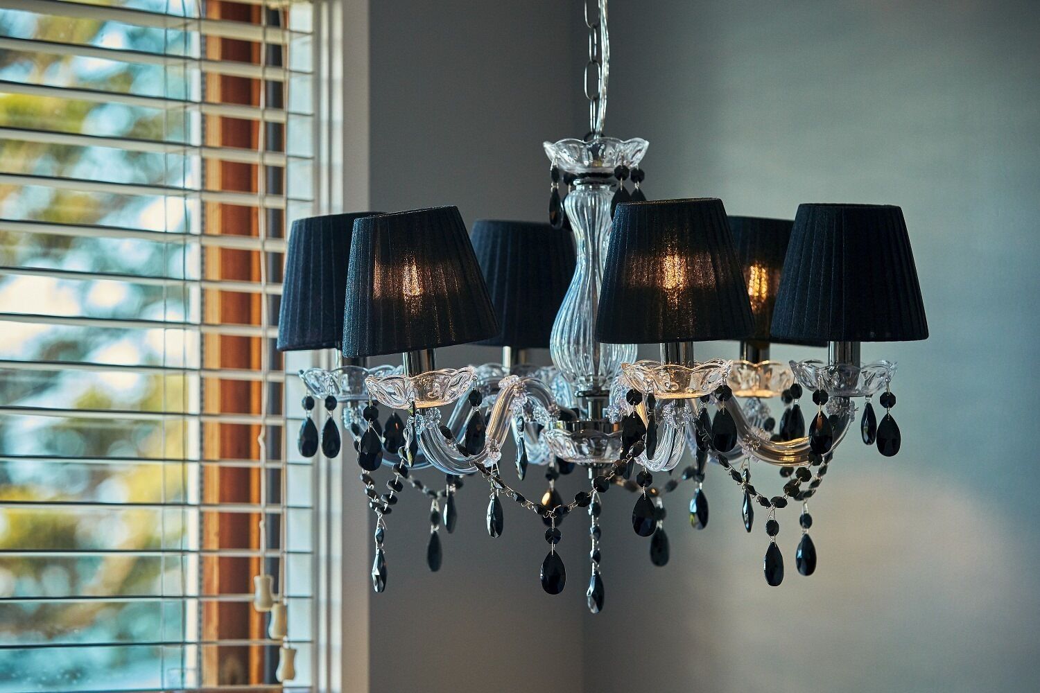 A chandelier with multiple lampshades and crystal decorations.