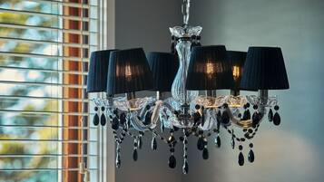 A chandelier with multiple lampshades and crystal decorations.