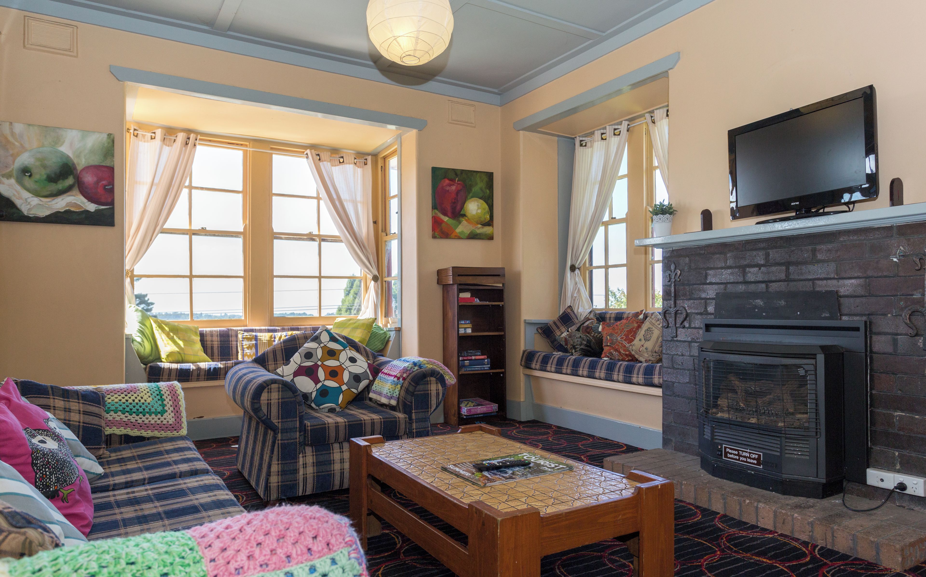 A living room with a sofa, a coffee table, a fireplace, and a television.