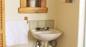 A bathroom with a white sink, two faucets, and a wooden medicine cabinet above it. - Katoomba Mountain Lodge (Katoomba)