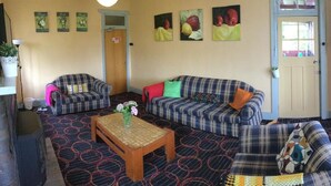 Una sala de estar con un conjunto de sofá, una mesa de centro y una alfombra estampada.