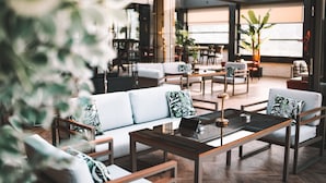 Un espace de détente moderne, aménagé avec des canapés, des tables et des chaises, propice aux échanges et à la convivialité.