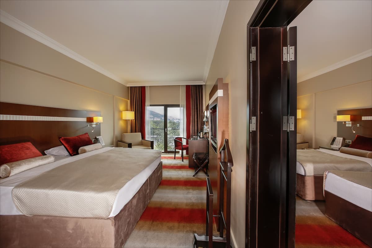 Een hotelkamer met twee bedden, een bureau en een stoel.