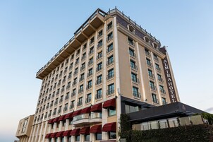 Un hotel alto con varios pisos, balcones y un cartel llamativo que dice "ALMIRAHOTEL".