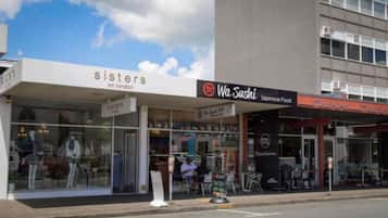 Une devanture de magasin avec les enseignes « Sisters on London » et « Wa Sushi, cuisine japonaise ».