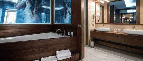 Une salle de bain moderne dotée d’une grande baignoire sur pieds, de deux vasques et d’un grand miroir.