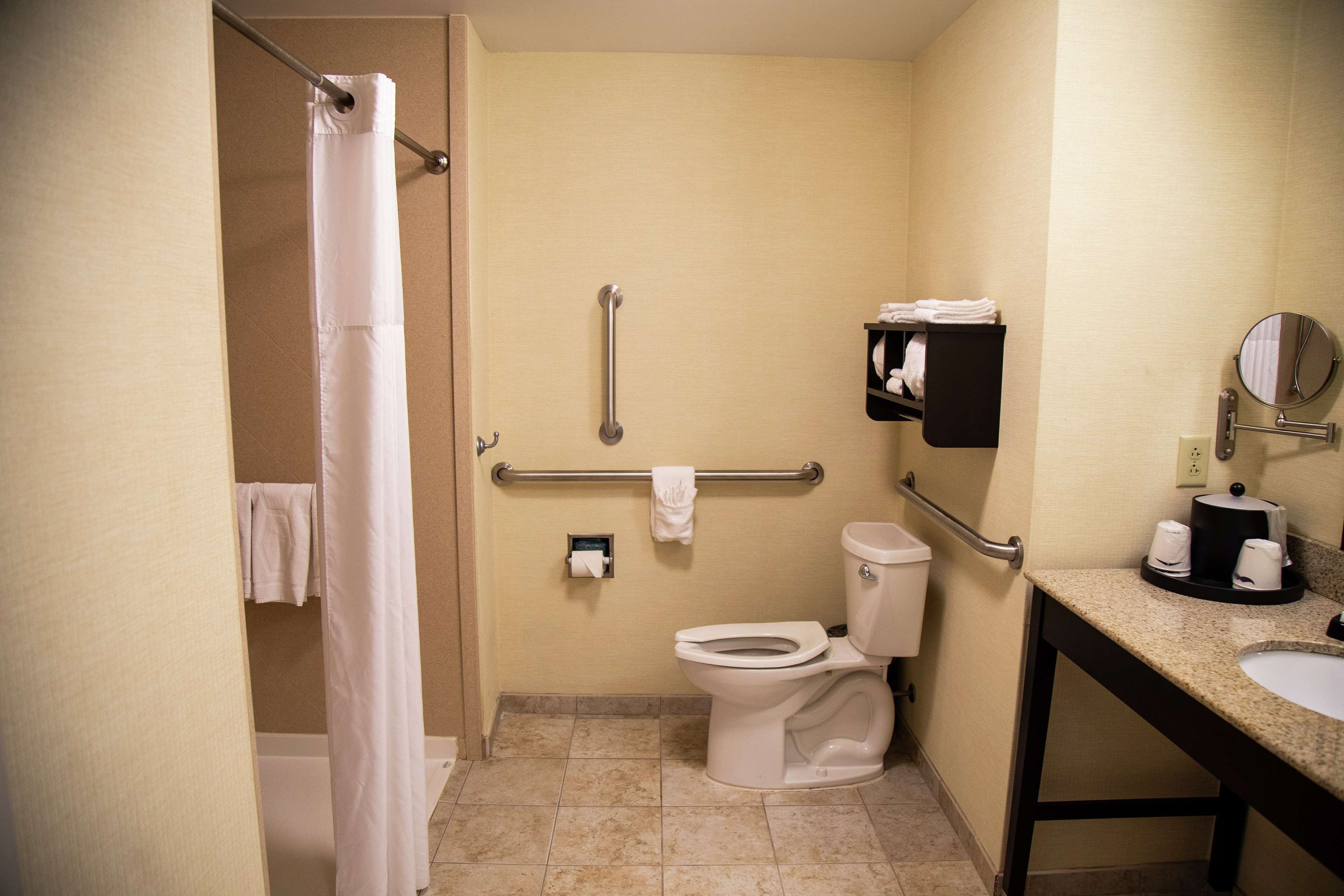 A small, clean bathroom with a toilet, sink, and shower curtain.