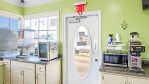 Una cocina equipada con microondas, cafetera y refrigerador.