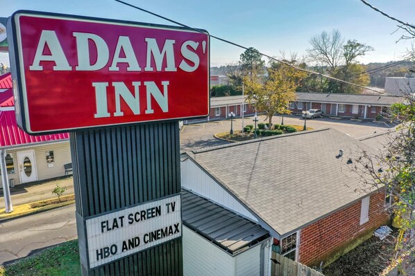 Señal de Adams' Inn con televisor de pantalla plana y HBO y Cinemax.