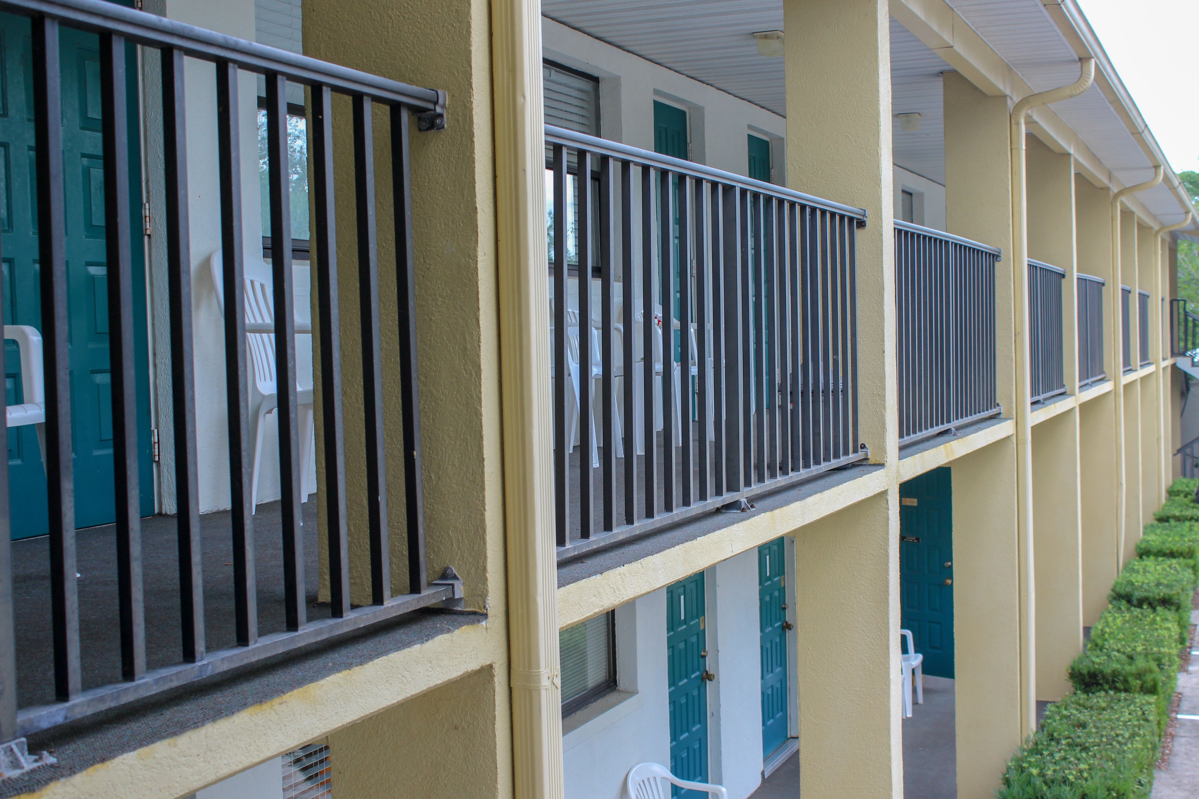 A multi-story hotel with balconies, doors, and windows.