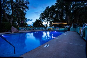 Relax by the serene pool surrounded by lush greenery, perfect for a leisurely soak.
