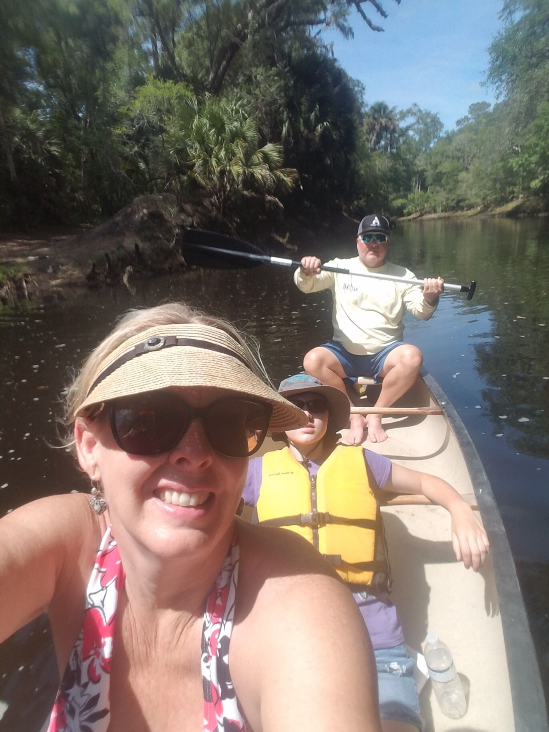 A boat on a river with people wearing life jackets.