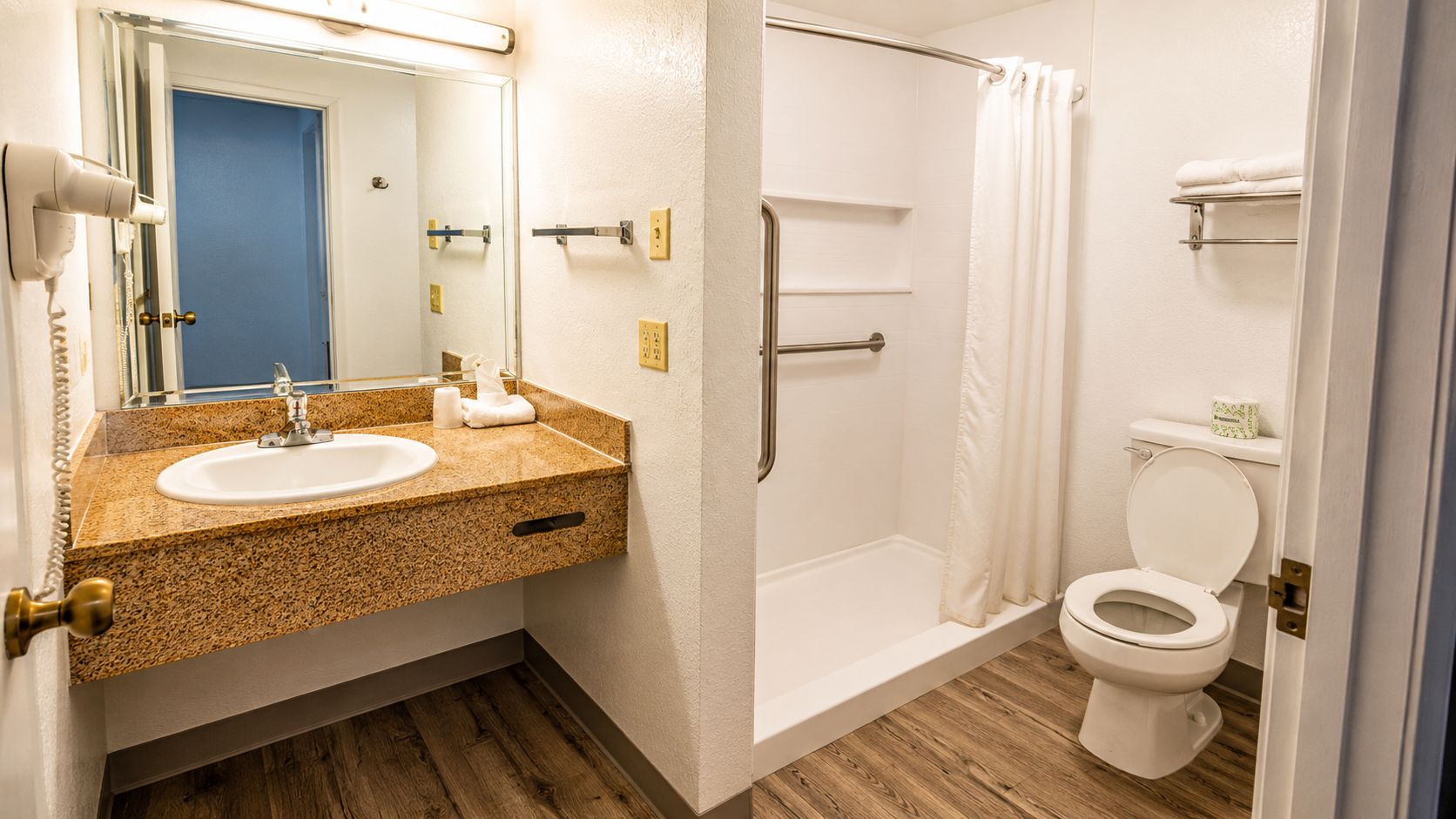 A bathroom with a sink, toilet, and shower.
