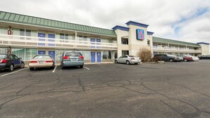 A motel with multiple rooms, a parking lot, and a clear sky. - Motel 6 Troy, OH (Troy)