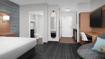 Une chambre d’hôtel moderne équipée d’un grand lit, d’un bureau, d’une télévision et d’une salle de bain.