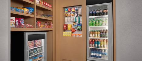 Un petit rayon d’épicerie avec des étagères remplies de collations, de boissons et d’autres produits.