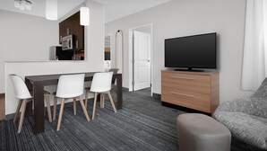A modern hotel room with a dining area, a TV, and a sofa. - TownePlace Suites Bridgeport Clarksburg (Clarksburg)