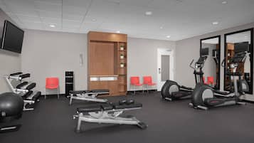 A gym with treadmills, elliptical machines, and free weights.
