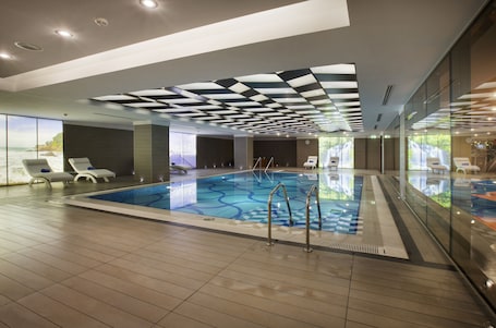 Una piscina techada, sillones reclinables de piscina