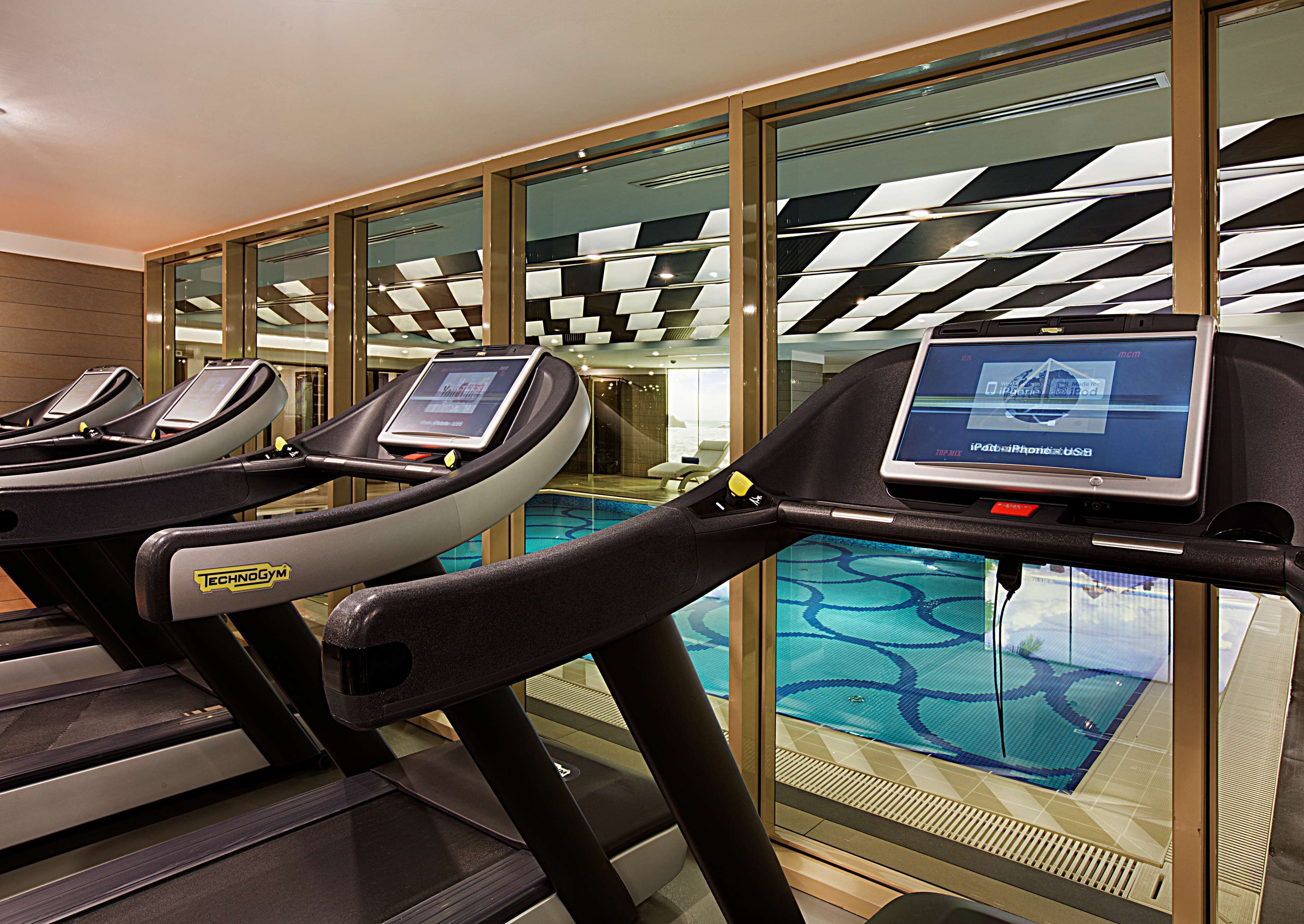 A gym with treadmills and a digital display.