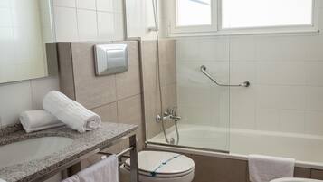 Un baño moderno con ducha, inodoro y lavamanos.