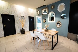 Un comedor con una mesa, sillas y espejos decorativos.
