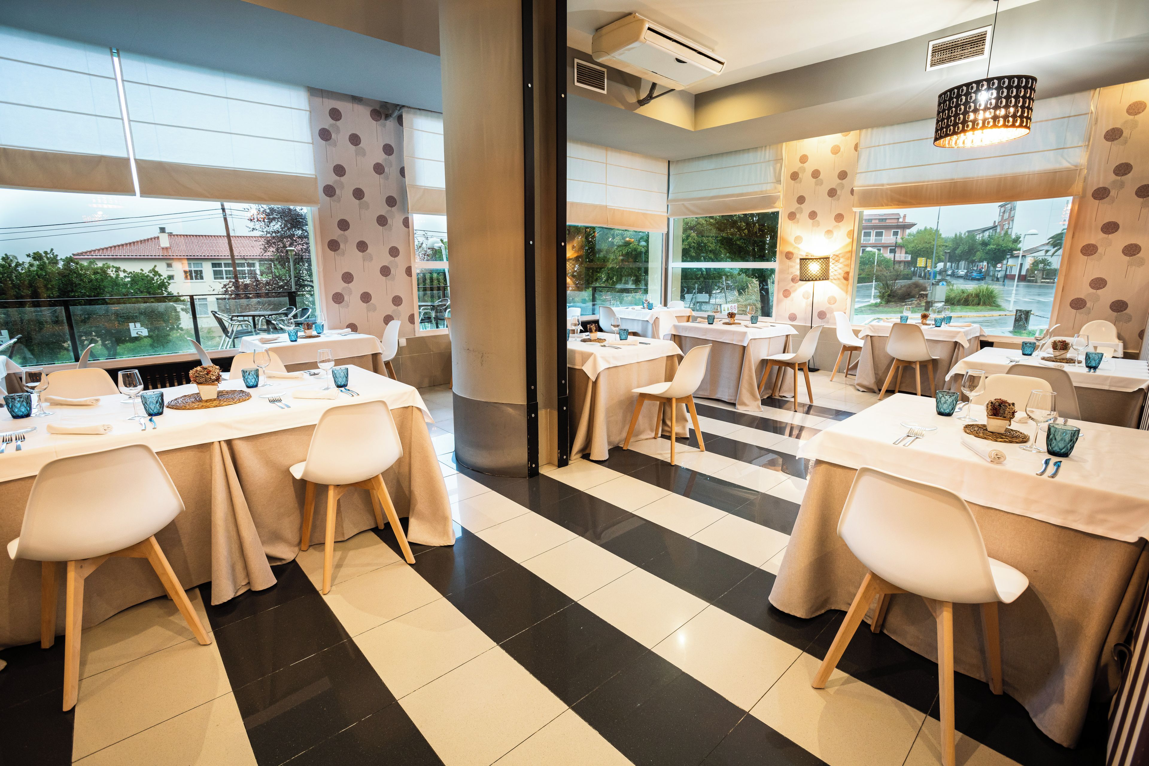 A restaurant with multiple tables, chairs, and a view of the city.