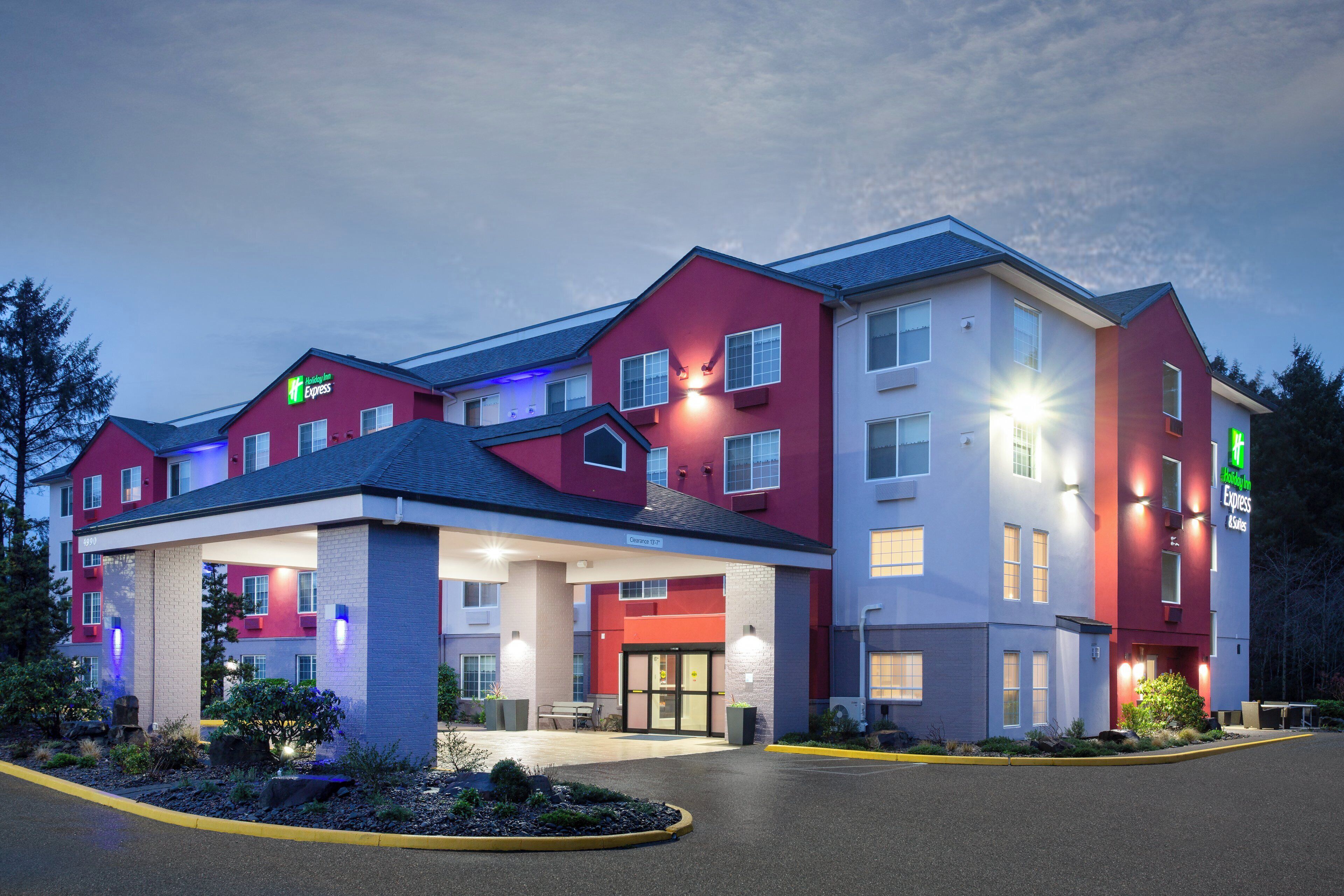 A Holiday Inn Express hotel with a red and white exterior, a covered entrance, and a parking lot.