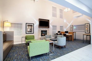 A spacious living area with a fireplace, seating, and a flat-screen TV.