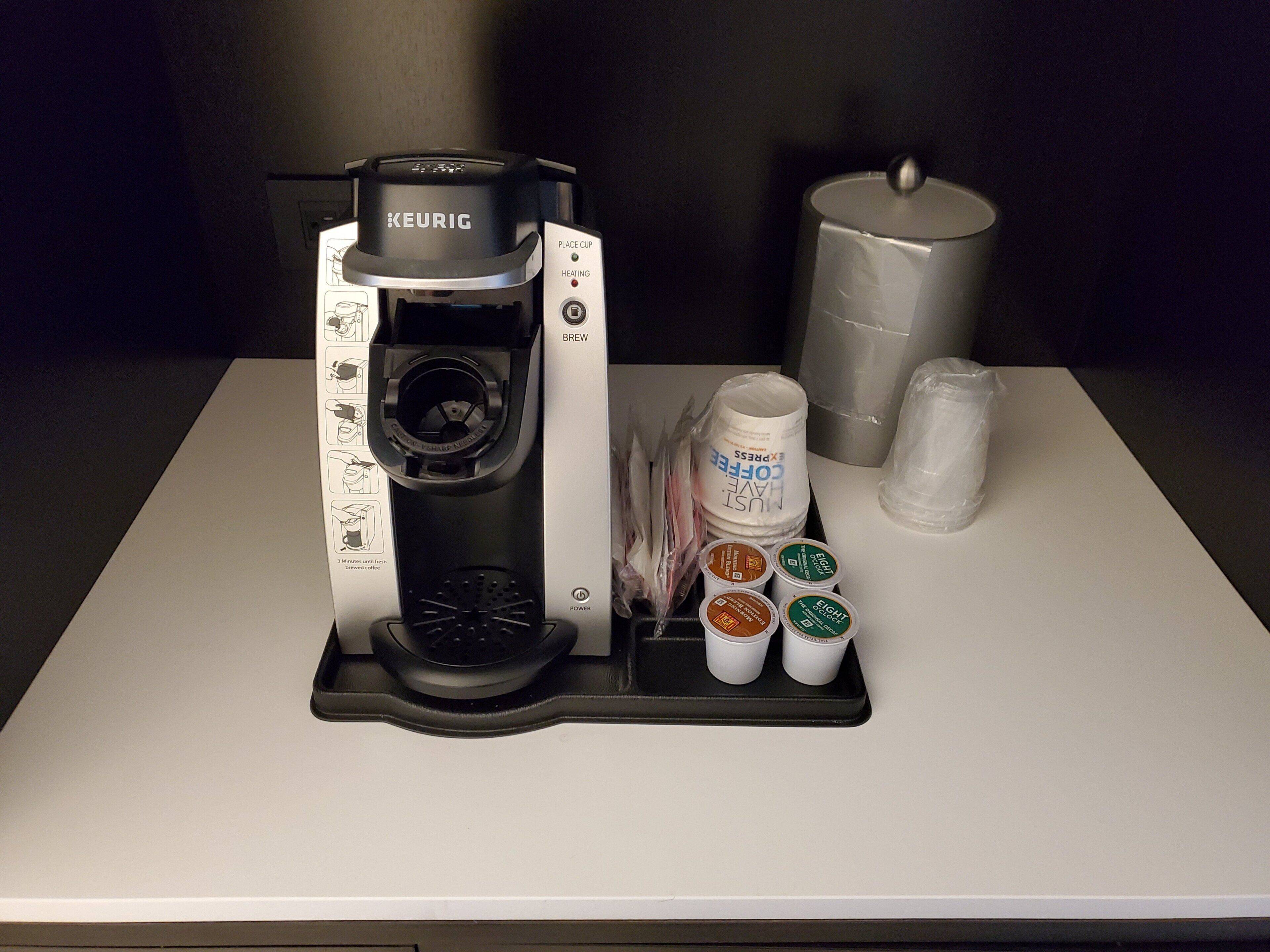 A Keurig coffee maker with a drip tray, a coffee pod holder, and a water reservoir.