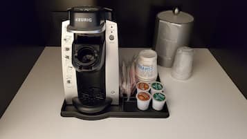 Una cafetera Keurig con bandeja de goteo, portacápsulas de café y depósito de agua.