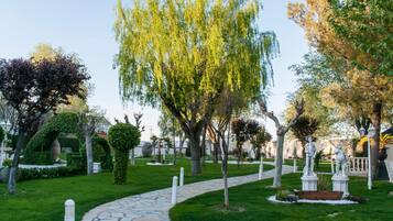 Un sendero en un jardín con estatuas y árboles.