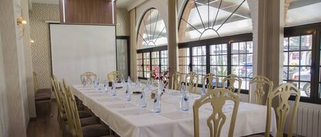 A conference room with a long table, chairs, and a whiteboard.