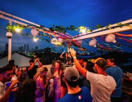 Una fiesta en la azotea con el horizonte de la ciudad al fondo.