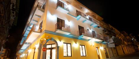 Vista frontal de la propiedad por la tarde o noche